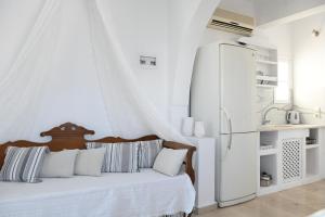 ein weißes Schlafzimmer mit Bett und Kühlschrank in der Unterkunft Villa Maina in Kamari