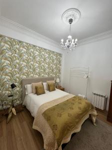 a bedroom with a large bed and a chandelier at Céntrico Apartamento in A Coruña