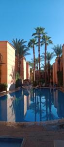 een zwembad met palmbomen in een resort bij Riad Sana in Marrakesh