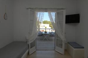 ein Zimmer mit Tür zu einer Terrasse mit Fenster in der Unterkunft Villa Maina in Kamari