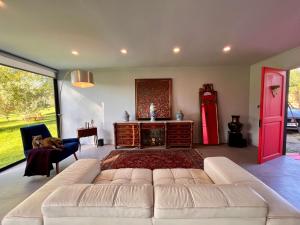 uma sala de estar com um sofá branco e um frigorífico vermelho em Casa Melipillán - Melipilla em Melipilla