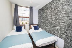 two beds in a room with a brick wall at 3 bed apartment, centre of Rochdale in Rochdale