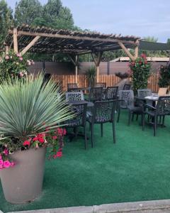 a patio with tables and chairs and a pergola at Mobil-home de la méditerranée in Vias