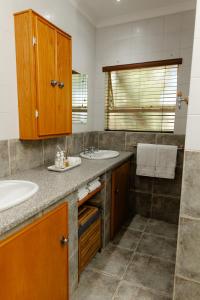 a bathroom with two sinks and a shower at Tristan's Place Guest House in Klerksdorp