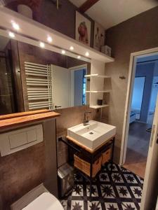 een badkamer met een wastafel, een toilet en een spiegel bij Moewennest-by-DeJu-Norderney in Norderney