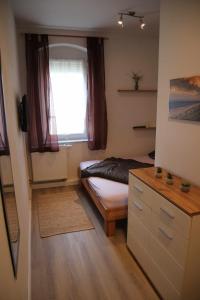 um pequeno quarto com uma cama e uma janela em Ferienwohnung am Windberg em Freital