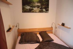 uma cama num quarto com uma pintura na parede em Ferienwohnung am Windberg em Freital