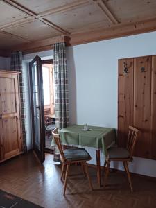 une salle à manger avec une table et des chaises vertes dans l'établissement Haus Mesner, à Innervillgraten