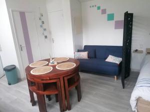een woonkamer met een tafel en een blauwe bank bij Studio Sulniac Golfe du morbihan in Sulniac