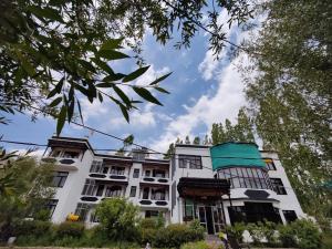 Dream Ladakh Guest House في ليه: مبنى أبيض ذو سماء زرقاء في الخلفية