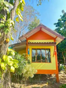 una casa pequeña con naranja y amarillo en Chill In Pai - ชิลล์ อิน ปาย, en Pai