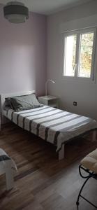 1 dormitorio con 1 cama grande en una habitación con ventana en Gîte Au pied du grand cèdre, en Vesseaux