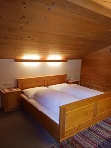 - une chambre avec un grand lit au plafond en bois dans l'établissement Haus Mesner, à Innervillgraten