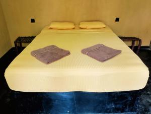 a bed with two towels on top of it at Milk House Cottage in Udawalawe