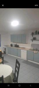 a kitchen with white cabinets and a table with a chair at Atlantic lodge in Ahnagh Cross