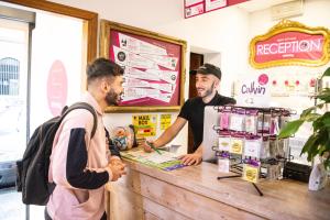 two men standing at a counter in a restaurant at Safestay Pisa Centrale in Pisa