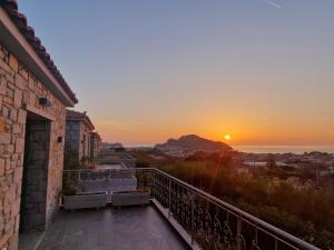 een zonsondergang vanaf het balkon van een huis bij AMYGDALIES STONE APARTMENTS in Mirina