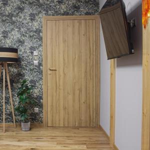a wooden door in a room with a wall at Apartament Sarenka in Rogożnik