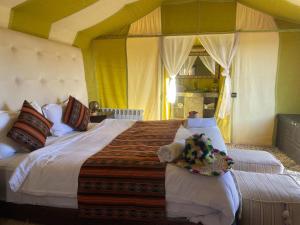 a bedroom with a large bed in a room at Luxury Camp Of Dar Morocco in Merzouga