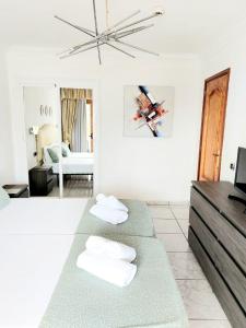 a bedroom with two beds and a living room at FIRST LINE Los Geranios Ocean View Apartment Air Conditioned 50 m from La Pinta beach in Adeje