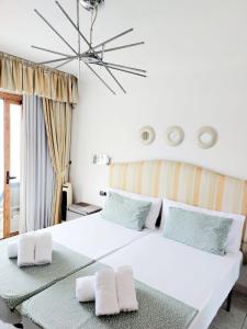 een slaapkamer met een groot wit bed met 2 kussens bij FIRST LINE Los Geranios Ocean View Apartment Air Conditioned 50 m from La Pinta beach in Adeje