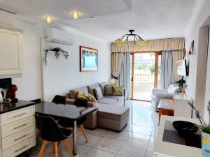 - un salon avec un canapé et une table dans l'établissement FIRST LINE Los Geranios Ocean View Apartment Air Conditioned 50 m from La Pinta beach, à Adeje