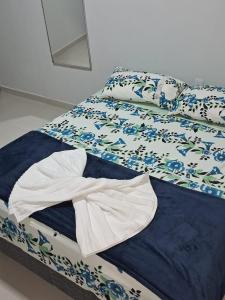 uma cama com um edredão e almofadas em Flat aconchegante com entrada privativa proximo ao aeroporto e rodoviária em Palmas