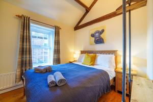 a bedroom with a bed with two towels on it at 2 Eden Grove Cottages in Armathwaite