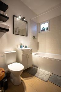 a bathroom with a toilet and a tub and a sink at Ultracentral Hong Kong 3 Bdrm apartment in Bucharest