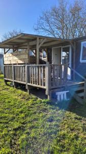 a small house with a porch and a deck at LE RHUYS, mobil home cosy proche des plages in Sarzeau