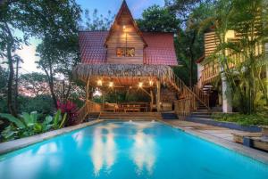 een huis met een zwembad voor een huis bij Treehouse Chilo at Hacienda Nosara in Playa Pelada