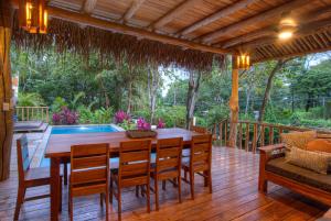 een houten terras met een houten tafel en stoelen bij Treehouse Chilo at Hacienda Nosara in Playa Pelada