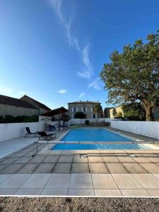 a swimming pool with a chair next to a house at Beautiful Charente Home with swimming pool in Marcillac-Lanville