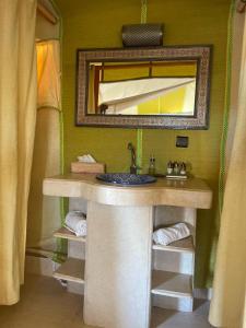 a bathroom with a sink and a mirror at Luxury Camp Of Dar Morocco in Merzouga
