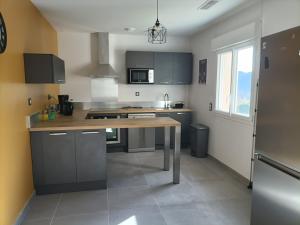 cocina con mesa de madera en una habitación en Gîte Au pied du grand cèdre, en Vesseaux