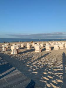 een strand met veel witte stoelen en de oceaan bij Apartamenty Grunwaldzka in Świnoujście