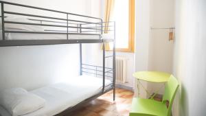 a bedroom with two bunk beds and a green chair at Safestay Pisa Centrale in Pisa