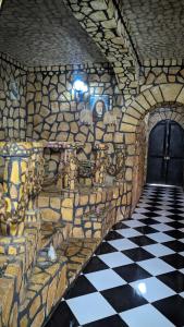 a stone wall with a black and white checkered floor at Châteaux Yolande in Mahajanga