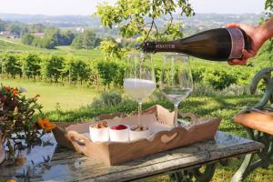 a bottle of wine being poured into two wine glasses at Alice Relais Nelle Vigne in Vittorio Veneto