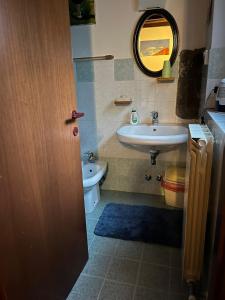 uma casa de banho com um lavatório, um WC e um espelho. em B&B Mirna em Vaprio dʼAdda