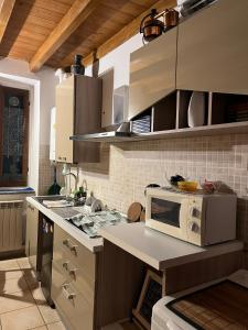 a kitchen with a microwave and a stove top oven at B&B Mirna in Vaprio dʼAdda