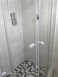 a shower with a glass door and a black and white floor at 49 on Bristow in Roodepoort