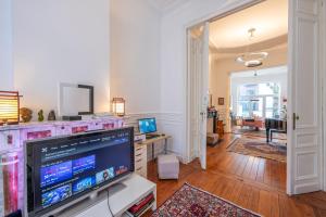 a living room with a large screen tv in a room at Euro Edens Brussels - Family Home & Free Gym Access in Brussels