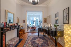 a living room with a piano and a mirror at Euro Edens Brussels - Family Home & Free Gym Access in Brussels