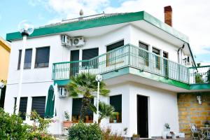 Casa blanca con balcón y palmeras en B&B Francesca, en Enna