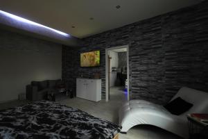 a bedroom with a brick wall and a white couch at Wellness apartmán Apawell in Nezdenice
