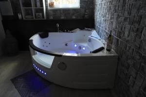 a white bath tub with lights in a bathroom at Wellness apartmán Apawell in Nezdenice