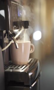 a coffee cup sitting on top of a coffee machine at 2 STODOŁY Chillout in Dziwnów