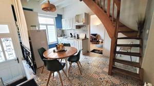 a kitchen with a table and chairs and a staircase at Gîte de la Belle Roze in Ardres