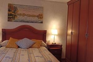 a bedroom with a bed and a lamp and a painting at Vivienda turística con terraza en Rioja Alavesa in Baños de Ebro +3 photos